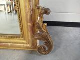 a large mirror with a gold frame on the floor