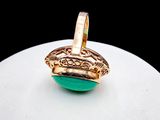 an image of a gold ring with a green stone