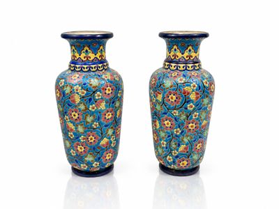 une paire de vases bleus ornés de motifs floraux sur fond blanc