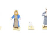 five figurines of people standing in front of a gas pump