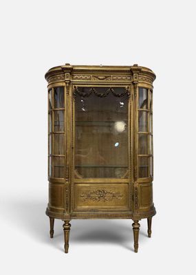 une vitrine ancienne dotée d'une porte vitrée et de garnitures dorées