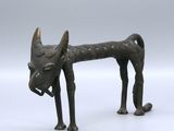 statue of a dog with horns on a white surface with a gray background