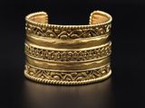 a close up of a gold bracelet on a black surface