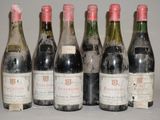 six bouteilles de vin sont alignées sur une table