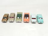 several toy cars are lined up in a row on a white surface
