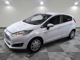 la ford fiesta blanche est garée dans une pièce au sol à carreaux