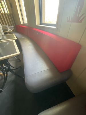 un banc avec une assise rouge près d'une fenêtre