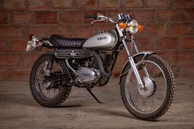 a motorcycle that is parked in front of a brick wall