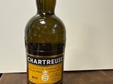une bouteille de Chartreuse posée sur une table en bois