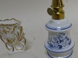 a small white and blue vase next to a small white and gold vase