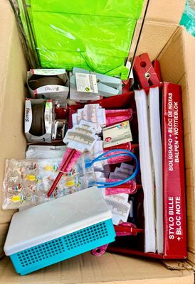 a cardboard box filled with supplies and a green bag