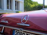 a close up of a red mercedes parked in front of a house