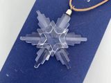 a clear snowflake on a brown cord on a blue book