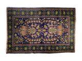 a blue rug with a design of elephants and birds on it