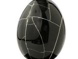 a black and white marble egg sitting on a stand
