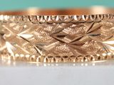 an image of a close up of a gold ring on a white surface