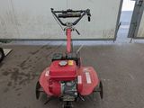an image of a red lawn mower parked in front of a building