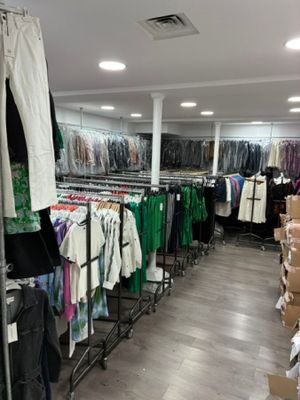 des portants remplis de vêtements dans un magasin de vêtements proposant un vaste choix de vêtements