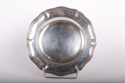 un plateau d'argent posé sur un support sur une surface blanche