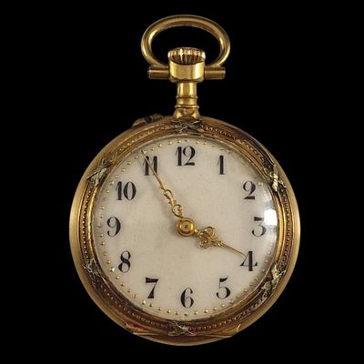 gros plan d'une montre de poche en or sur fond noir