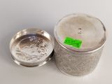 a close up of a silver container with a green label on it