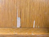 a close up of a wood paneled wall with peeling paint on it
