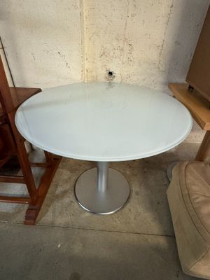 une table et une chaise blanches dans un coin d'une pièce