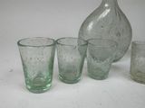 bottles and glasses on a white surface with a bottle in the background