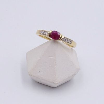 gros plan d'une bague en or avec un rubis et des diamants