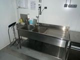 a stainless steel sink in a room with a metal counter