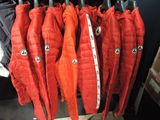 many red jackets hanging on a rack in a store