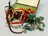 a box filled with assorted jewelry on a white surface