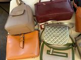 many bags and purses on a table in a room