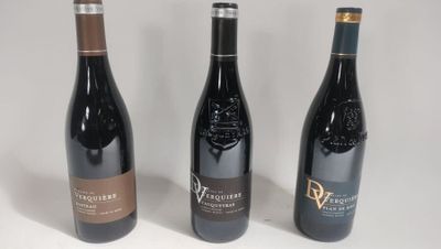 three bottles of wine are lined up on a white surface