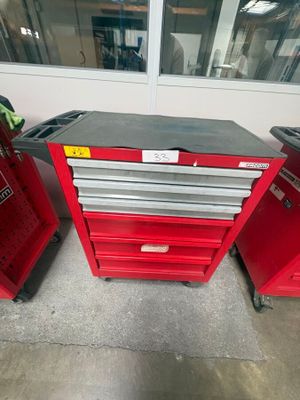 Deux caisses à outils rouges sont posées l'une à côté de l'autre dans un garage.