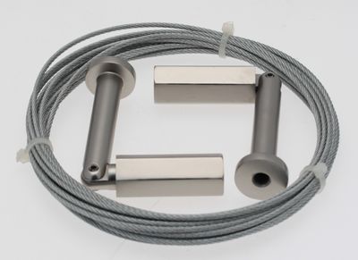 un gros plan d'un câble et d'un tube métallique sur une surface blanche