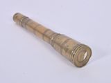 an old brass telescope on a white surface with a white background
