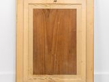 an old picture frame with a wooden surface and a white wall