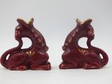 pair of red ceramic figurines of a cat with a crown on its head