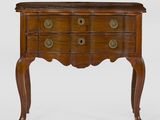 une petite commode en bois posée sur un socle