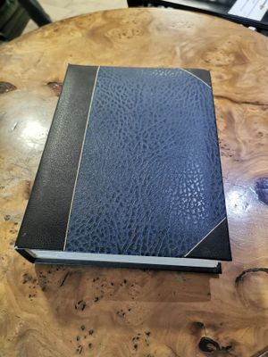 a blue book on a wooden table with a keyboard in the background