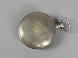 an old silver pocket watch sitting on top of a table