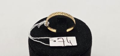 un gros plan d'une bague en or posée sur un présentoir noir