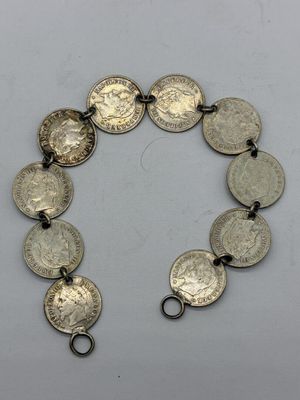 un gros plan d'un bracelet orné de pièces de monnaie