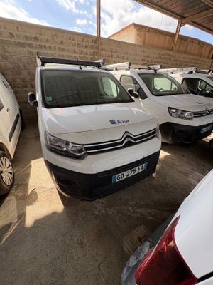 des voitures garées sur un parking devant un mur de briques