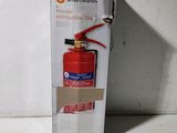 un extincteur rouge dans une boîte en carton