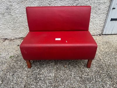 an image of a red bench sitting in front of a building