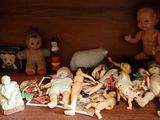 une étagère sur laquelle sont posées plein de poupées et de jouets