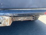 a close up of a car with a rusted bumper