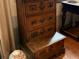 a wooden chest of drawers in the corner of a room